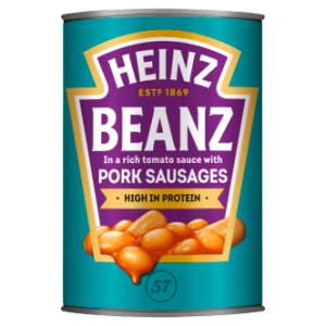 A can of Heinz Beans and Sausages in a rich tomato sauce with pork sausages is shown. The label is teal with a purple shield-shaped design featuring the text "Heinz Beanz" and "High in protein." An illustration of the beans and sausages is depicted at the bottom.