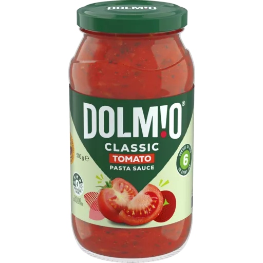 A jar of smooth Dolmio Smooth Tomato Sauce Jar with a green lid. The label shows "Dolmio" in bold white letters, with "Classic Tomato" underneath. There is an image of sliced tomatoes and fresh green leaves. The jar contains 500g of sauce and highlights a 6-ingredient recipe.